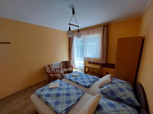 a bedroom with two beds and a living room at Petra Vendégház in Bük