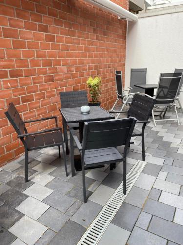 um pátio com uma mesa e cadeiras e uma parede de tijolos em Ferienhaus Leuchtfeuer em Norderney