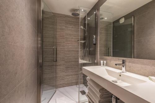 a bathroom with a sink and a shower at Chalet Hôtel Le Prieuré & Spa in Chamonix-Mont-Blanc