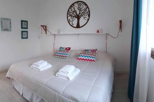 a white bed with towels on top of it at CasaSana Wellness in Charbonier