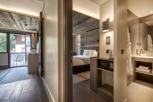 a bedroom with a bed and a bathroom with a mirror at Chalet Hôtel Le Prieuré & Spa in Chamonix-Mont-Blanc