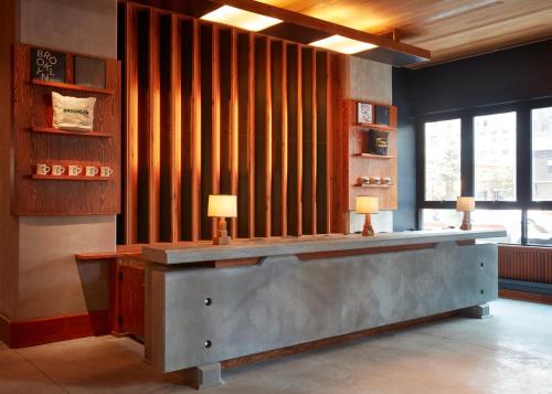 a lobby with a reception desk with two lamps at Ace Hotel Brooklyn in Brooklyn