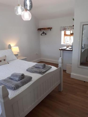 a bedroom with a white bed with towels on it at Meadowsweet @ Laneside in Whitby