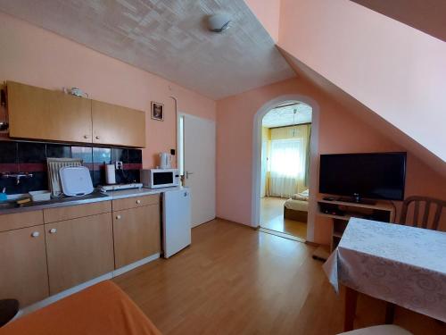 a kitchen with an open floor plan with a table at Petra Vendégház in Bük
