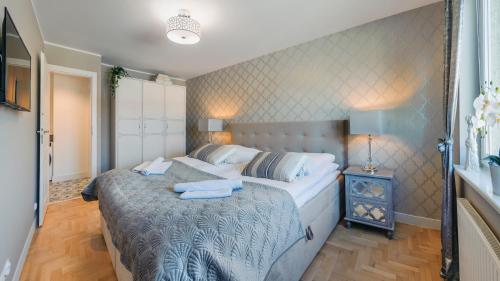 a bedroom with a bed with two towels on it at Apartamenty Sun & Snow Leśna in Hel