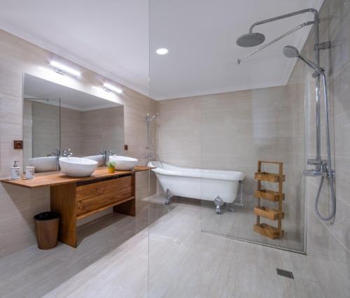 a bathroom with two sinks and a tub and a shower at Семеен хотел и ресторант Райски залив in Golyama Zhelyazna