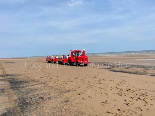 a red truck driving on the beach at Mablethorpe Seaside - Jepson Beach Retreat in Mablethorpe