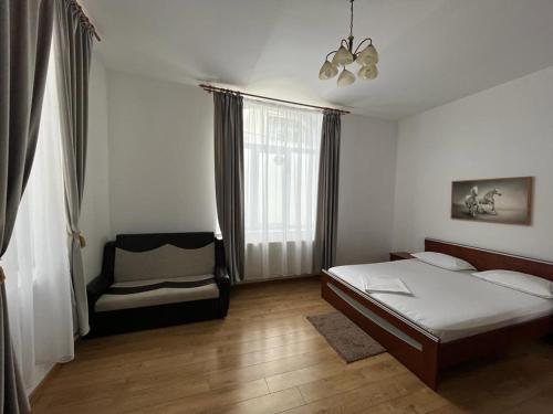 a bedroom with a bed and a chair in it at Vila Ada in Bucharest