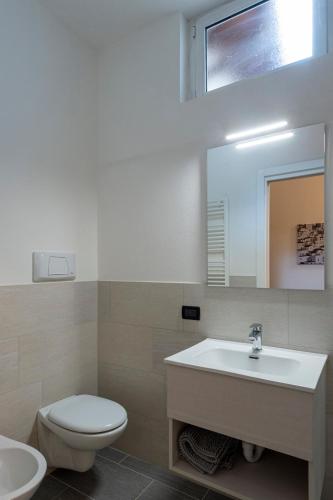 a bathroom with a sink and a toilet and a mirror at Casa David in Stresa