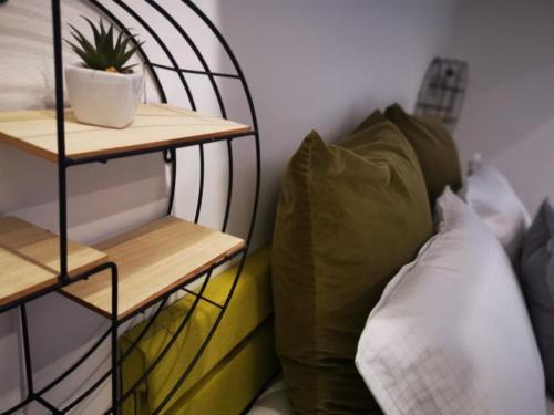a room with a pillow and a plant on a shelf at Apartment Keleia in Celje