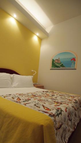 a hotel room with a bed with a colorful blanket at Piccolo Hotel in Moneglia