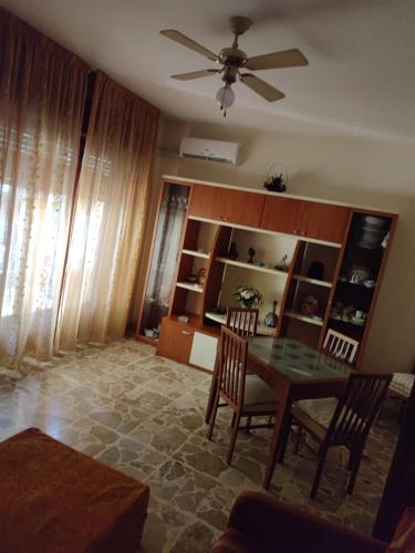 a living room with a table and chairs and a ceiling fan at Appartamento Elisa in Melito di Porto Salvo