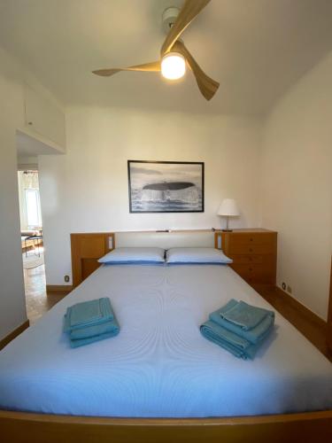 una camera da letto con un grande letto con cuscini blu di Appartamento Victoria a Camogli