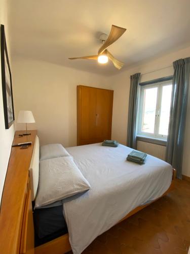 a bedroom with a large bed with a ceiling fan at Appartamento Victoria in Camogli