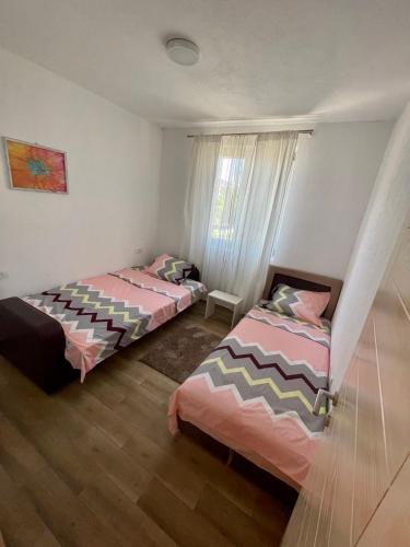 two beds sitting in a room with a window at Talia Apartments in Budva