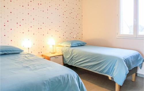- 2 lits installés l'un à côté de l'autre dans une chambre dans l'établissement Stunning Home In Pirou With Wifi, à Pirou