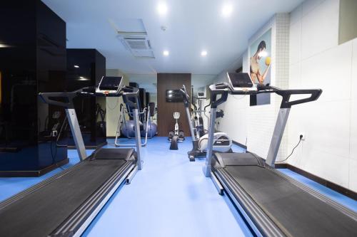a gym with treadmills and machines in a room at Hotel Dukagjini in Peje
