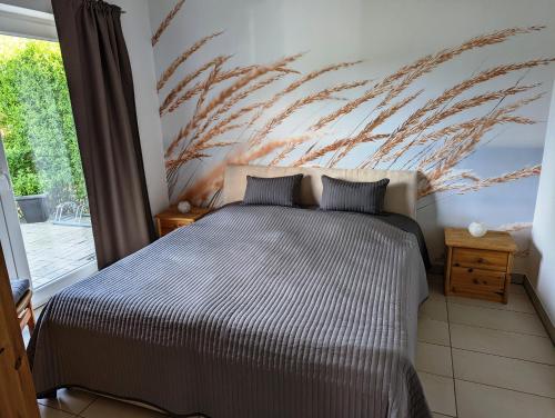 ein Schlafzimmer mit einem Bett und einem Gemälde an der Wand in der Unterkunft Ferienwohnungen direkt am See bei den Kaiserbädern in Bansin