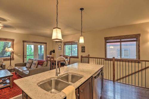 a kitchen with a sink and a living room at Walkable Bigfork Townhome Fish, Hike and Ski! in Bigfork