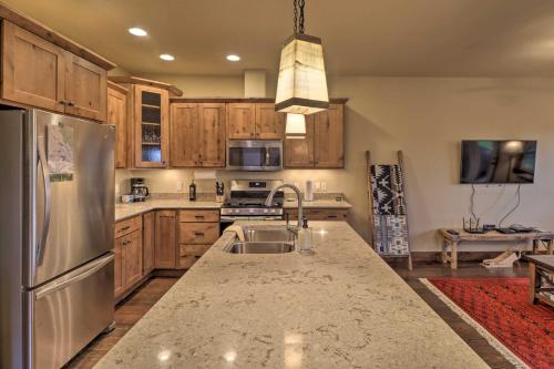 a kitchen with wooden cabinets and a stainless steel refrigerator at Walkable Bigfork Townhome Fish, Hike and Ski! in Bigfork