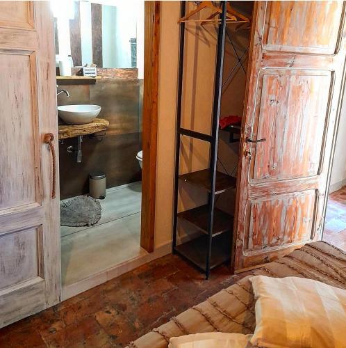 a bathroom with a sink and a wooden door at Toscana Made in Love in Massa