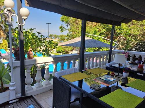 un balcon avec une table, des chaises et un parasol dans l'établissement SUITE-Junior -Villa HÉLÈNE - Montpellier Sud - aéroport- PISCINE Privée-2mn des plages, à Pérols