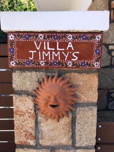 eine lächelnde Sonne an einer Wand mit einem Schild in der Unterkunft Villa Jimmy, Pilona Village in vlicha