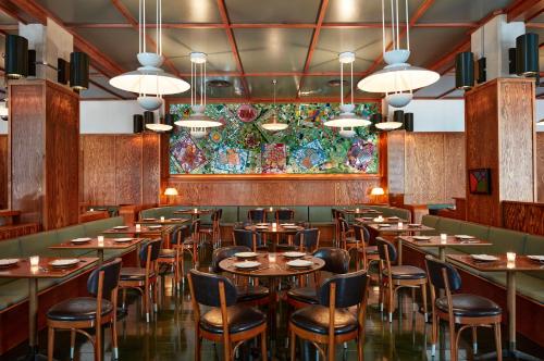 a restaurant with tables and chairs and a colorful wall at Ace Hotel Brooklyn in Brooklyn