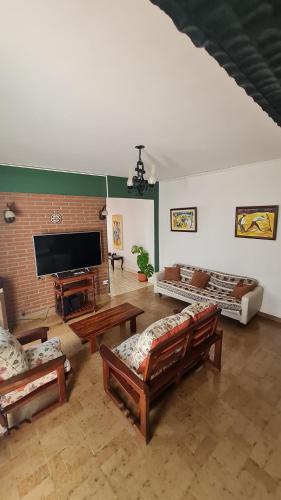 una gran sala de estar con sofás y una pared de ladrillo. en Casa de Güemes Salta Capital en Salta