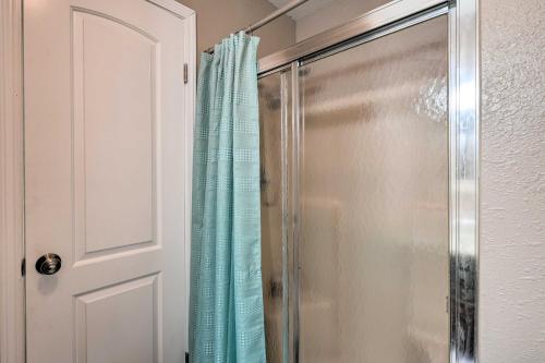 a shower with a blue shower curtain next to a door at Reeds Spring Condo Near Aquarium at the Boardwalk! in Reeds Spring