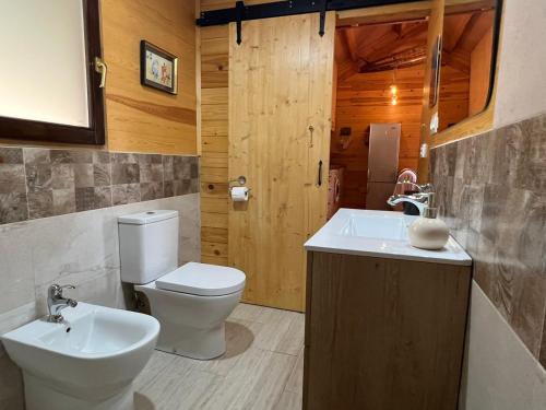 a bathroom with a toilet and a sink at Rustic Cabin in the Woods/Cabaña en el bosque in Girona
