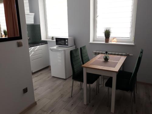 a kitchen with a table and chairs and a microwave at Apartament do wynajęcia in Mikołajki