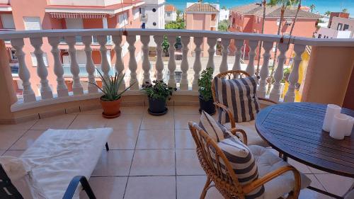 d'un balcon avec une table, des chaises et une clôture. dans l'établissement Apto. con wifi, piscina, vistas al mar y parking., à Moncofa