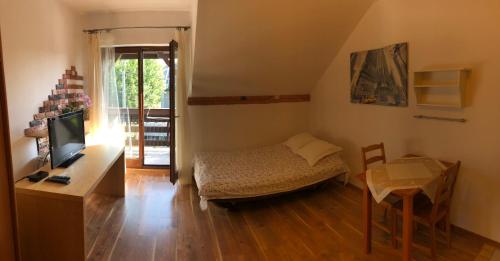 a small room with a bed and a table with a television at Apartament Bronowice in Krakow
