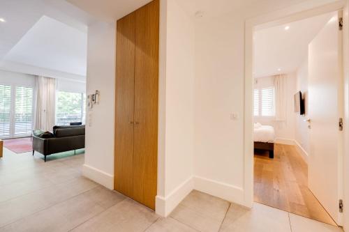 a living room with white walls and a wooden door at Le Kube - Appartements de Prestige au centre d'Annecy in Annecy