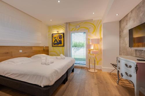 a bedroom with a large bed and a television at Le Kube - Appartements de Prestige au centre d'Annecy in Annecy
