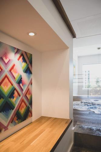 a large colorful painting on the wall in a room at Le Kube - Appartements de Prestige au centre d'Annecy in Annecy