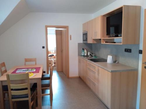 a kitchen and dining room with a table and a counter top at Apartmány VAKSTAV Dolní Morava in Dolní Morava