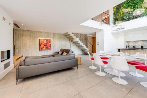 a living room with a couch and a table and chairs at Le Kube - Appartements de Prestige au centre d'Annecy in Annecy