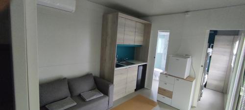 a small kitchen with a couch and a refrigerator at Kamp Katra Mobilna hiška ECO in Vinica