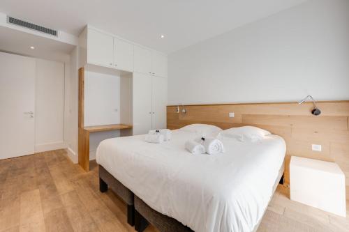 a bedroom with a large white bed with white pillows at Le Kube - Appartements de Prestige au centre d'Annecy in Annecy