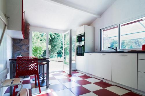 - une cuisine avec un sol en damier rouge et blanc dans l'établissement Le Mas d'Argens - Maison avec Jardin et Jacuzzi - Accès rivière, à Lorgues
