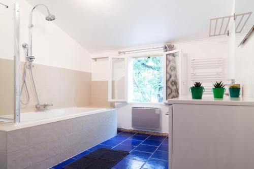 une salle de bain avec une baignoire et une fenêtre dans l'établissement Le Mas d'Argens - Maison avec Jardin et Jacuzzi - Accès rivière, à Lorgues