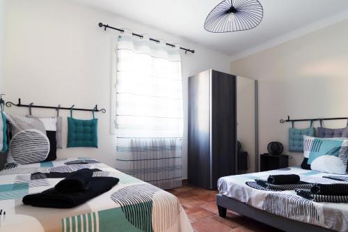 1 dormitorio con 2 camas y ventana en Le Mas d'Argens - Maison avec Jardin et Jacuzzi - Accès rivière, en Lorgues