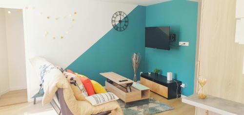 a living room with a couch and a blue wall at The Lagoon - Sublime studio moderne in Dreux