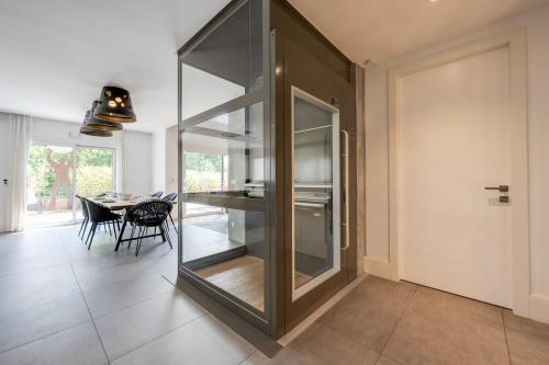 a kitchen with a glass partition with a dining table at Le Kube - Appartements de Prestige au centre d'Annecy in Annecy