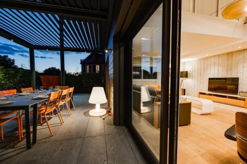 an open patio with a dining table and a living room at Le Kube - Appartements de Prestige au centre d'Annecy in Annecy