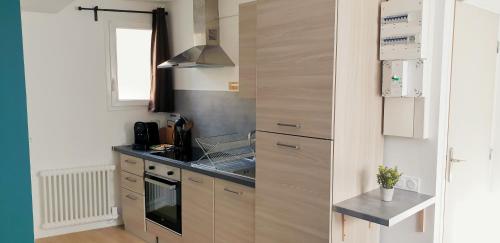 a small kitchen with a sink and a stove at The Lagoon - Sublime studio moderne in Dreux
