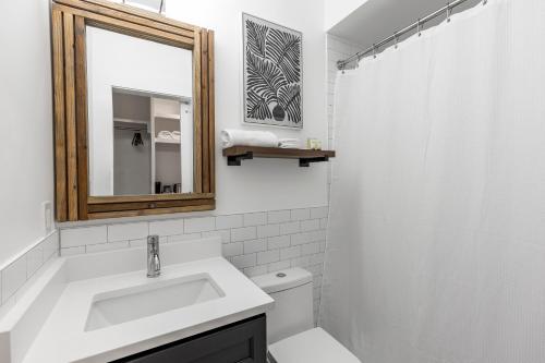 a white bathroom with a sink and a mirror at Marsh Hotel in New Orleans