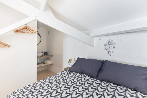 une chambre avec un lit dans une pièce blanche dans l'établissement La Galerie Pornic - Maison Cedre, à Pornic